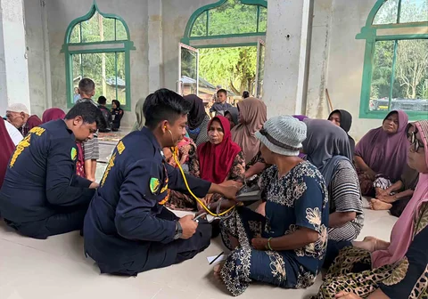 Tim medis Polri memberikan pemeriksaan kesehatan kepada warga terdampak banjir di Desa Bukit Seulema, Kecamatan Birem Bayeun, Aceh Timur, Jumat (16/01/2026).