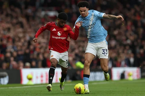 Penyerang Manchester United asal Pantai Gading  Amad Diallo (kiri) berduel dengan gelandang Manchester City asal Inggris Nico O'Reilly (kanan) selama pertandingan sepak bola Liga Premier Inggris antara Manchester United dan Manchester City di Old Trafford, Manchester, barat laut Inggris, Sabtu (17/01/2026).