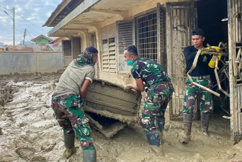Prajurit Yonif 115/Macan Leuser membersihkan lumpur dan sampah sisa banjir di Kantor MPD Kuala Simpang, Aceh Tamiang, guna mempercepat pemulihan fasilitas pelayanan, Sabtu (17/01/2026).
