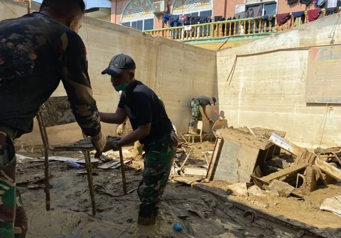 Prajurit Yonif 115/Macan Leuser membersihkan lumpur dan sampah sisa banjir di Kantor MPD Kuala Simpang, Aceh Tamiang, guna mempercepat pemulihan fasilitas pelayanan, Sabtu (17/01/2026).