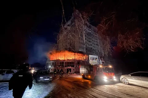 Petugas pemadam kebakaran berdiri di dekat bangunan tempat tinggal yang terbakar usai serangan pesawat tak berawak Rusia di Zaporizhzhia, Ukraina, Jumat (02/101/2026).