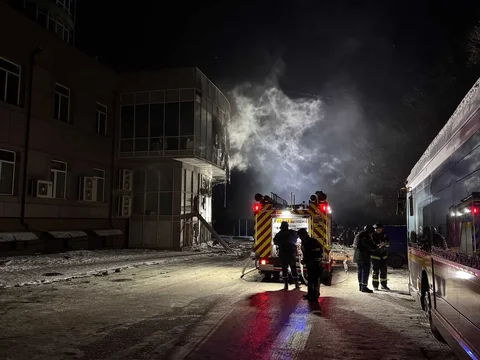Petugas pemadam kebakaran berdiri di dekat bangunan tempat tinggal yang terbakar usai serangan pesawat tak berawak Rusia di Zaporizhzhia, Ukraina, Jumat (02/101/2026).