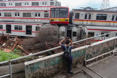 Seorang anak menyaksikan  tumpukan gerbong kereta rel listrik (KRL) bekas di Jalan Kampung Rawageni, Cipayung, Kota Depok, Selasa (20/01/2026).
