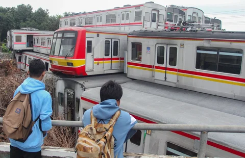 Anak-anak melihat tumpukan gerbong kereta rel listrik (KRL) bekas di Jalan Kampung Rawageni, Cipayung, Kota Depok, Selasa (20/01/2026).