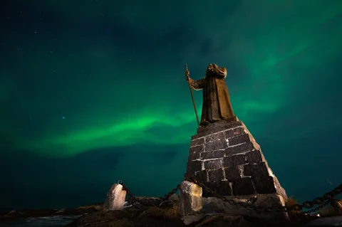 Aurora borealis menerangi langit malam di atas rumah-rumah penduduk di Nuuk, Greenland, Jumat (23/01/2026) waktu setempat.
