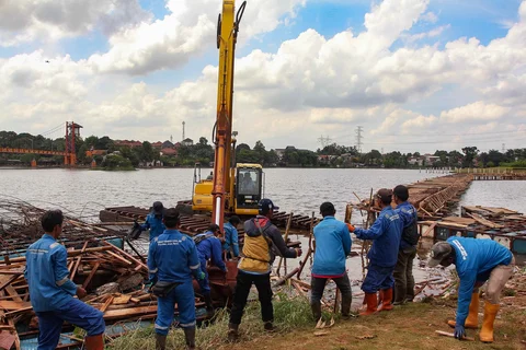 Petugas Dinas Sumber Daya Air Pemprov Jawa Barat membongkar tiang pancang beton yang dipasang di Setu Tujuh Muara, Sawangan, Depok, Senin (16/01/2026).