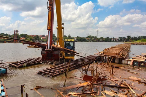 Petugas Dinas Sumber Daya Air Pemprov Jawa Barat membongkar tiang pancang beton yang dipasang di Setu Tujuh Muara, Sawangan, Depok, Senin (16/01/2026).