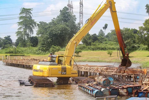 Petugas Dinas Sumber Daya Air Pemprov Jawa Barat membongkar tiang pancang beton yang dipasang di Setu Tujuh Muara, Sawangan, Depok, Senin (16/01/2026).