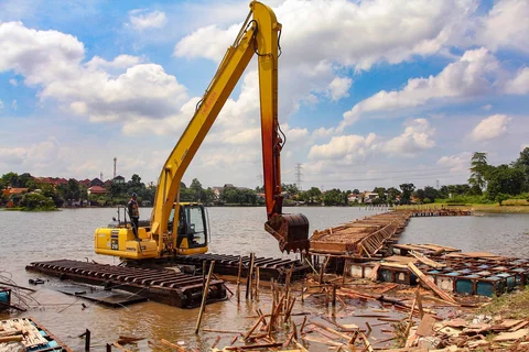 Petugas Dinas Sumber Daya Air Pemprov Jawa Barat membongkar tiang pancang beton yang dipasang di Setu Tujuh Muara, Sawangan, Depok, Senin (16/01/2026).