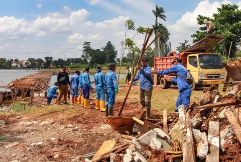 Petugas Dinas Sumber Daya Air Pemprov Jawa Barat membongkar tiang pancang beton yang dipasang di Setu Tujuh Muara, Sawangan, Depok, Senin (16/01/2026).
