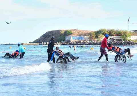 Para peserta berjalan keluar dari laut setelah sesi terapi air kelompok di Dakar, Senegal, Sabtu (06/12/2025).
