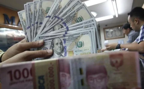 Karyawan menunjukkan uang rupiah dan dolar AS di Jakarta, Rabu (30/12/2020). Nilai tukar rupiah di pasar spot ditutup menguat 80 poin atau 0,57 persen ke level Rp 14.050 per dolar AS. (Liputa