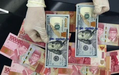 Petugas menghitung uang pecahan US$100 di pusat penukaran uang, Jakarta, , Rabu (12/8/2015). Reshuffle kabinet pemerintahan Jokowi-JK, nilai Rupiah terahadap Dollar AS hingga siang ini menemb