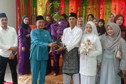 Kantor Urusan Agama (KUA) Bintan Timur menginisiasi program unik, mengajak setiap pengantin baru tanam pohon usai akad nikah, menyelaraskan kebahagiaan rumah tangga dengan kelestarian alam melalui gerakan Kemenag Asri.