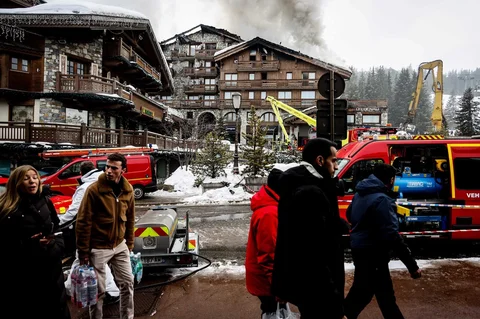 Orang-orang berlalu lalang saat petugas pemadam kebakaran berjuang memadamkan kebakaran hebat di hotel bintang lima Grandes Alpes di resor ski elite Courchevel, Alpen Prancis, Rabu (28/1/2026).