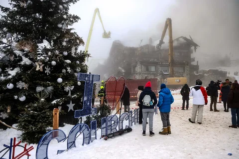 Orang-orang menyaksikan petugas pemadam kebakaran memadamkan kebakaran hebat di hotel bintang lima Grandes Alpes di resor ski elite Courchevel, Alpen Prancis, Rabu (28/1/2026).