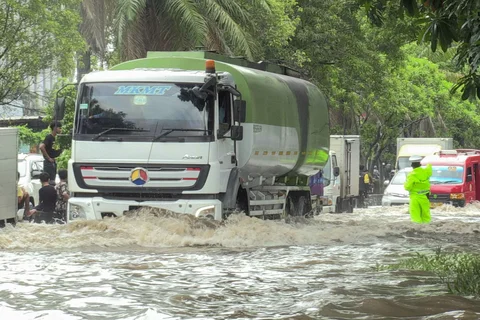 Petugas polantas mengatur arus lalu lintas kendaraan bermotor yang menerobos banjir di ruas Jalan Daan Mogot, Jakarta, Kamis (29/1/2026).