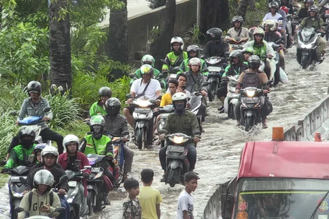 Petugas polantas mengatur arus lalu lintas kendaraan bermotor yang menerobos banjir di ruas Jalan Daan Mogot, Jakarta, Kamis (29/1/2026).