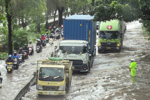 Petugas polantas mengatur arus lalu lintas kendaraan bermotor yang menerobos banjir di ruas Jalan Daan Mogot, Jakarta, Kamis (29/1/2026).