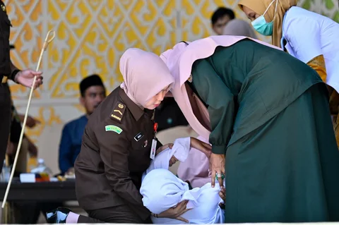 Seorang wanita pingsan setelah dicambuk di depan umum oleh anggota polisi Syariah di Banda Aceh,  Kamis (29/01/2026).