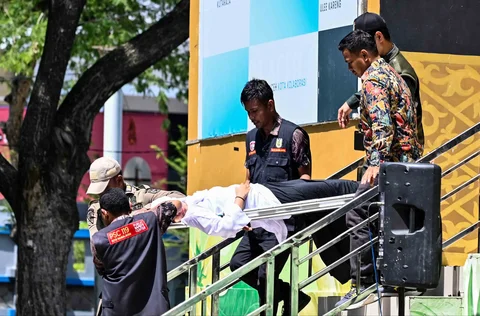 Tim medis dan anggota polisi syariah membawa seorang wanita yang pingsan setelah dicambuk di depan umum oleh seorang anggota polisi syariah di Banda Aceh, Kamis (29/01/2026).