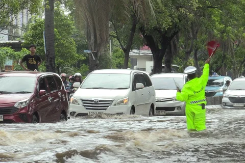 Petugas polantas mengatur arus lalu lintas kendaraan bermotor yang menerobos banjir di ruas Jalan Daan Mogot, Jakarta, Kamis (29/1/2026).