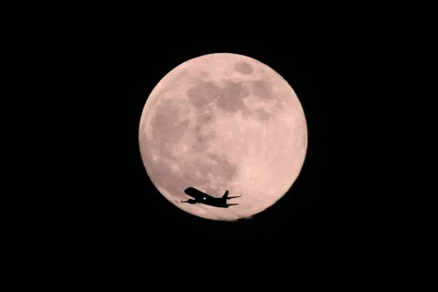 Sebuah pesawat terbang melintas di depan Supermoon Serigala di Chicago. Amerika Serikat, Jumat (02/01/2026).  <br />AP Photo/Kiichiro Sato