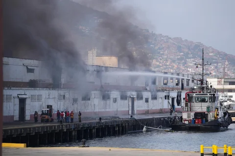 Asap mengepul dari dermaga setelah ledakan terdengar di pelabuhan La Guaira, Venezuela, Sabtu (03/0/2026) waktu setempat.