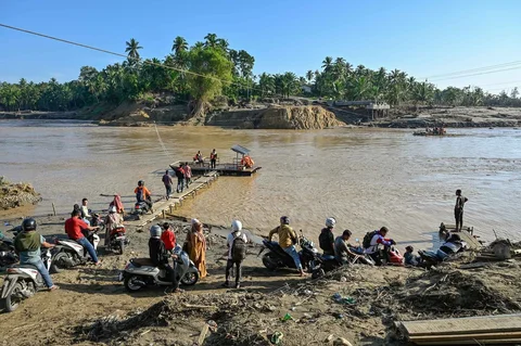 Warga antri menggunakan rakit penyeberangan untuk menyeberangi sungai Peusangan di Ulee Jalan, Peusangan Selatan, Bireuen, Aceh, Senin (05/01/2026).