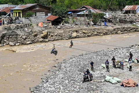 Warga menggunakan tali untuk menyeberangi sungai pascabanjir bandang di Ketol, Aceh, Selasa (06/01/2026).
