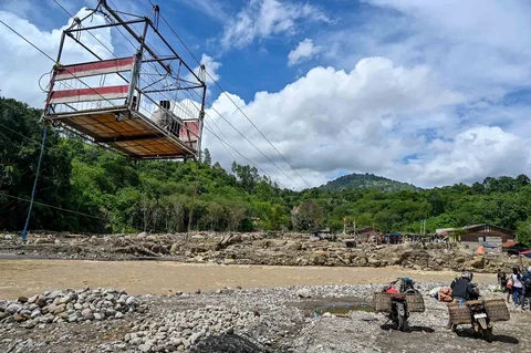 Warga menggunakan tali untuk menyeberangi sungai pascabanjir bandang di Ketol, Aceh, Selasa (06/01/2026).