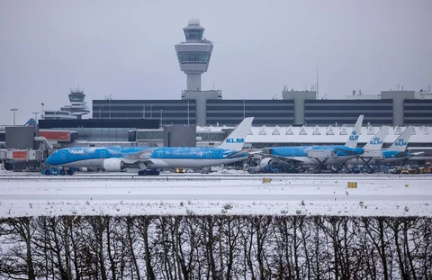 Pesawat-pesawat maskapai penerbangan Belanda KLM di landasan pacu saat hujan salju bandara Amsterdam Schiphol, Belanda, Rabu (07/01/2026).