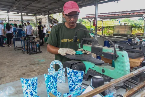 Pekerja menyelesaikan produk kerajinan tangan berbagan sampah plastik  di Bank Sampah Kertabumi, Pondok Aren, Tangerang Selatan, Kamis (08/01/2026),