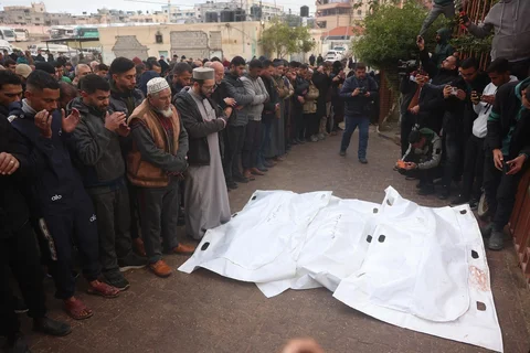 Warga Palestina berdoa di atas jenazah kerabat mereka sebelum dimakamkan, sehari setelah penembakan militer Israel yang menewaskan lebih dari selusin orang termasuk anak-anak, di Rumah Sakit Nasser di Khan Yunis, di Jalur di Kota Gaza,  Palestina,  Jumat (09/01/2026).