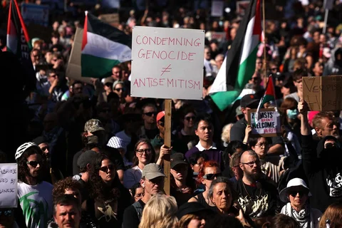 Para pengunjuk rasa memegang bendera dan spanduk di luar stasiun Flinders Street di Melbourne, Australia, Kamis (12/02/2028).