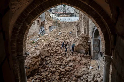 Anak-anak Palestina berjalan melewati reruntuhan Masjid Agung Omari yang rusak akibat serangan Israel di Kota Gaza,  Rabu (12/02/2026).