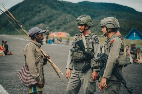 Personel Satgas Tindak Operasi Damai Cartenz 2026 berinteraksi dengan warga saat patroli dialogis di sela pengamanan hari pasar di Distrik Kiwirok, Papua Pegunungan, Jumat (13/02/2026).