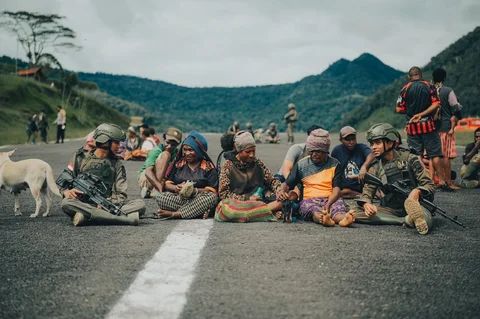 Personel Satgas Tindak Operasi Damai Cartenz 2026 berinteraksi dengan warga saat patroli dialogis di sela pengamanan hari pasar di Distrik Kiwirok, Papua Pegunungan, Jumat (13/02/2026).