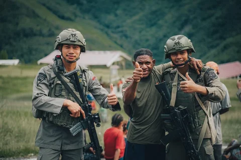 Personel Satgas Tindak Operasi Damai Cartenz 2026 berinteraksi dengan warga saat patroli dialogis di sela pengamanan hari pasar di Distrik Kiwirok, Papua Pegunungan, Jumat (13/02/2026).