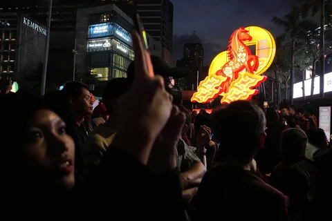 Warga berfoto di instalasi lampu saat perayaan Festival Imlek Jakarta di Bundaran HI, Jakarta, Jumat (13/2/2026) malam.