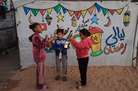 Anak-anak  bermain membawa lampion Ramadan di kamp pengungsi Bureij di Jalur Gaza tengah, Minggu (15/02/2026).