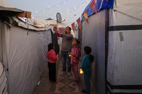 Para pengungsi Palestina memasang  lampion Ramadan di samping tenda mereka di kamp pengungsi Bureij di Jalur Gaz, Minggu (15/02/2026).