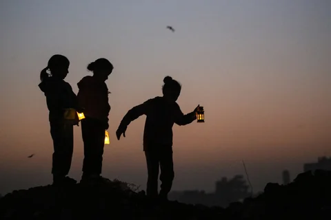 Anak-anak  bermain di reruntuhan bangunan yang hancur sambil membawa lampion Ramadan di kamp pengungsi Bureij di Jalur Gaza tengah  Minggu (15/02/2026).