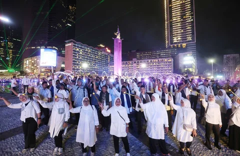Peserta memegang obor elektrik saat mengikuti acara Transisi Ramadhan 1447 H di Bundaran HI, Jakarta, Selasa (17/2/2026).