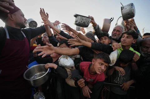 Para pengungsi Palestina berebut menerima sumbangan makanan untuk iftar atau makan berbuka puasa pada hari pertama bulan suci Ramadan di dapur umum di Khan Younis, Jalur Gaza, Rabu (18/02/2026).