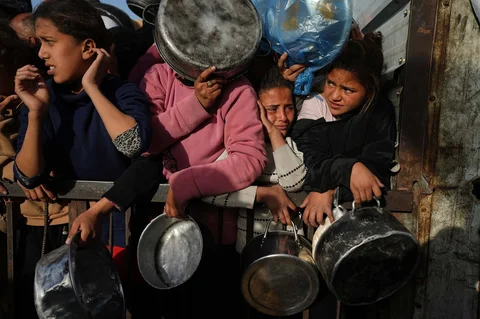 Para pengungsi Palestina berebut menerima sumbangan makanan untuk iftar atau makan berbuka puasa pada hari pertama bulan suci Ramadan di dapur umum di Khan Younis, Jalur Gaza, Rabu (18/02/2026).