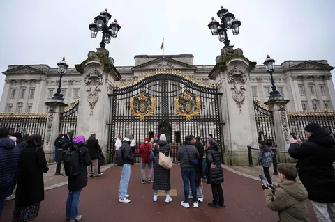 Para pengunjung  menyaksikan gerbang Istana Buckingham di London  pada Kamis (19/01/2026), setelah Andrew Mountbatten-Windsor ditangkap oleh polisi Inggris atas dugaan pelanggaran dalam jabatan publik.