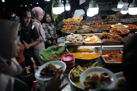 Warga memilih lauk makanan sebelum berbuka puasa  pada hari kedua bulan suci Ramadan di Sentra Kuliner Kapau Raya di Jalan Kramat Raya, Jakarta, Indonesia, Jumat (20/02/2026)..