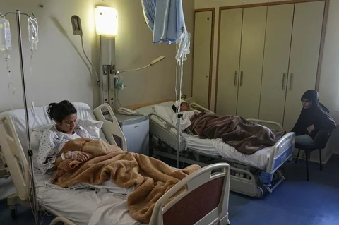 Maha al-Jassem, warga Suriah (tengah), dan putrinya Razan al-Jassem (kiri), yang terluka dalam serangan udara Israel, berbaring di Rumah Sakit Rayak di Lebanon timur, Sabtu, (21/02/2026).
