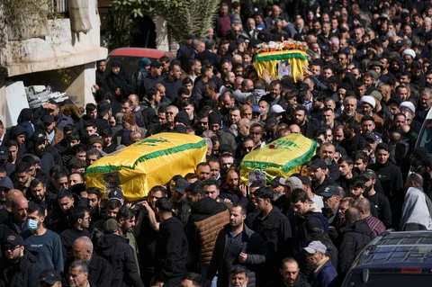 Para pelayat membawa peti mati tiga pejuang Hizbullah yang tewas dalam serangan Israel selama prosesi pemakaman mereka di desa Nabi Sheet di Lebanon timur, Sabtu, (21/02/2026).